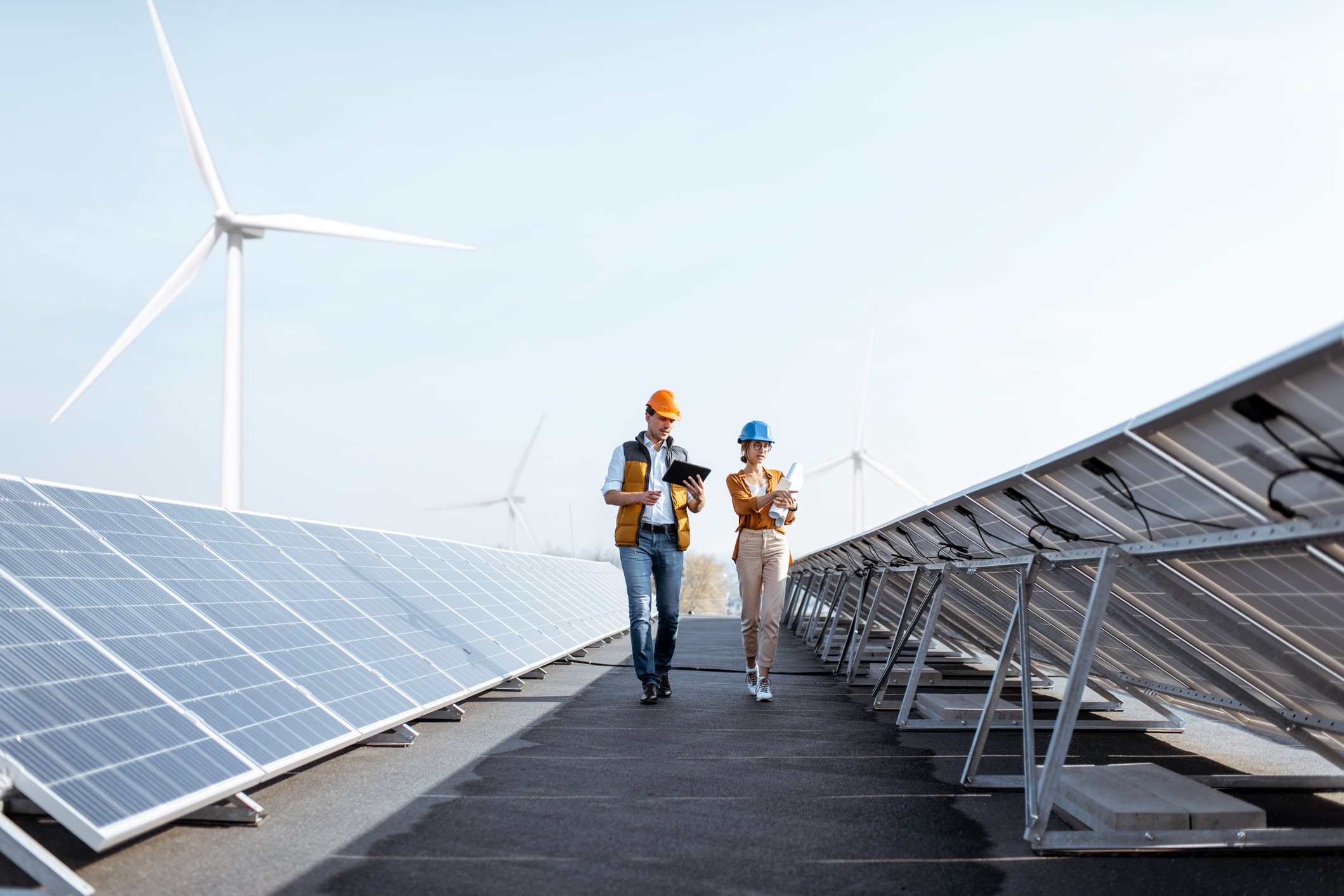 utility workers walking between solar panels