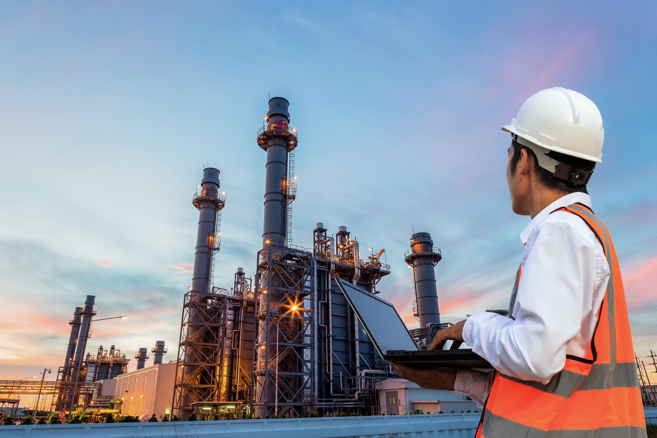 oil and gas employee looking at a plant