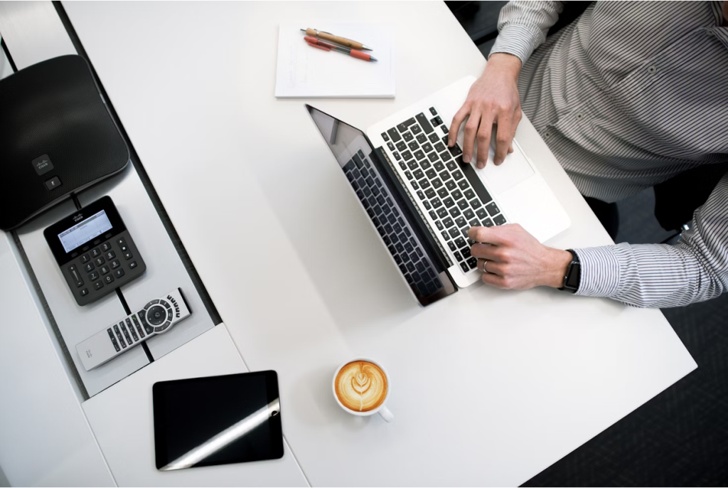 A business professional using his laptop on a white table