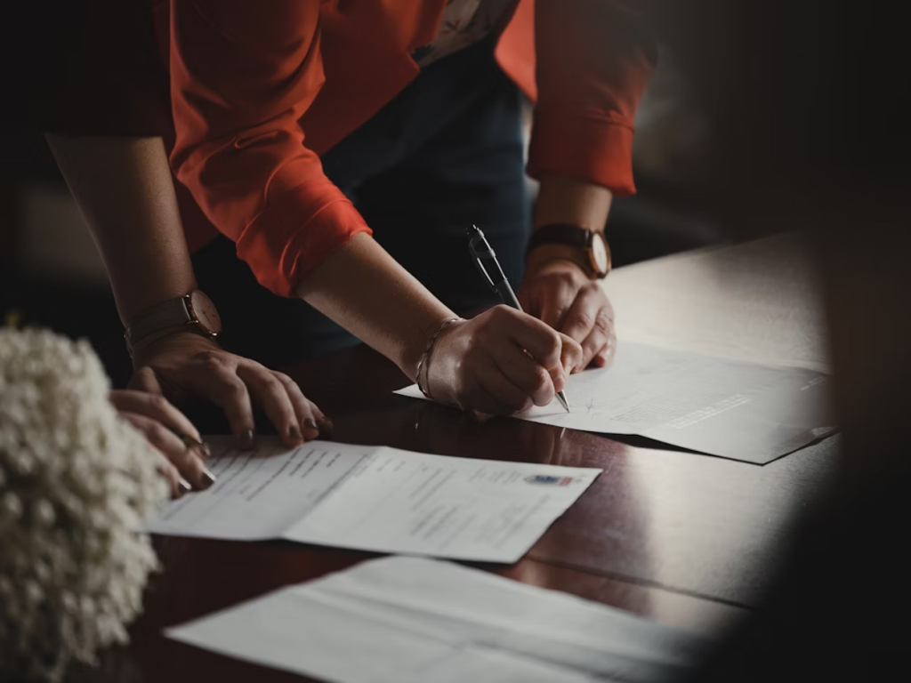 Business professionals signing documents at a desk