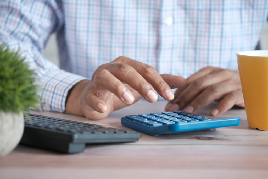 A person using a calculator on a desk