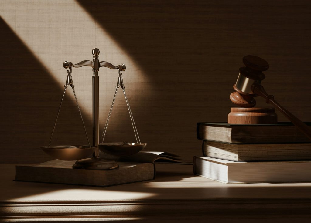 Balance scales and gavel on law books in warm lighting