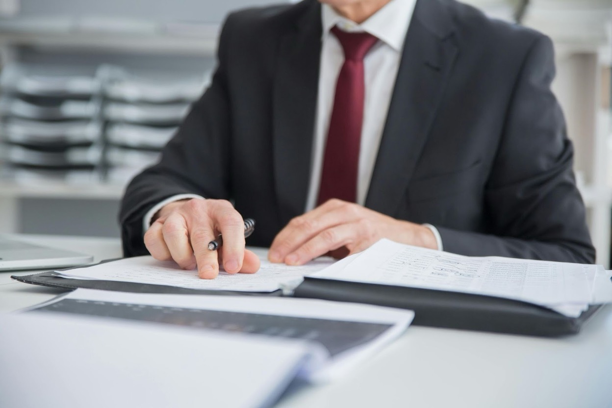 Financial analyst reviewing documents at an office desk