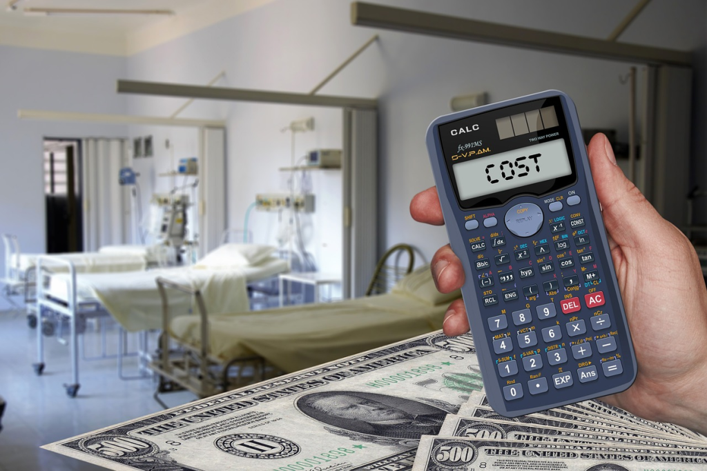 Hand holding a calculator displaying the word "COST" over cash and dollar bills with a hospital room visible in the background