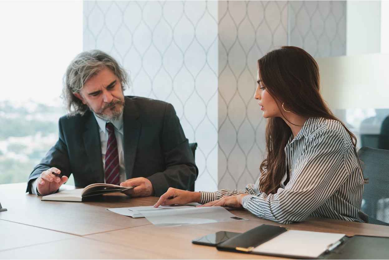 Professionals from a collection agency discussing account status during a meeting in a modern office setting.