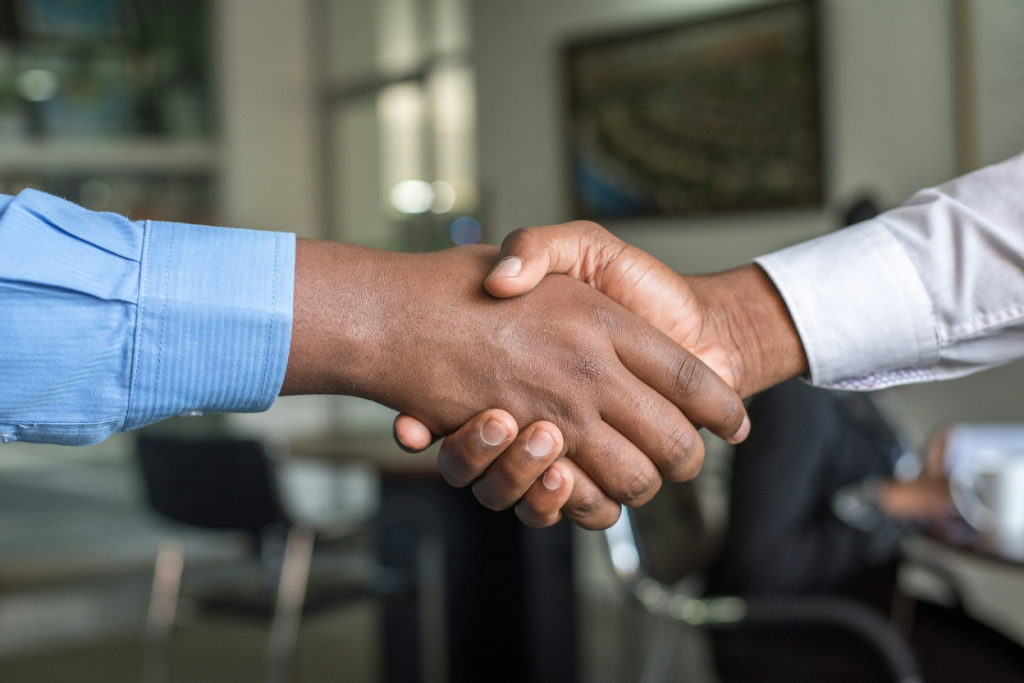 Two business professionals shaking hands in an office setting