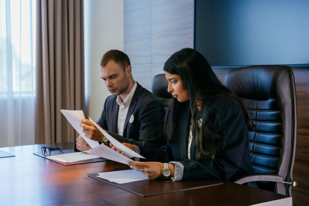 Business attorneys reviewing litigation documents in a conference room.