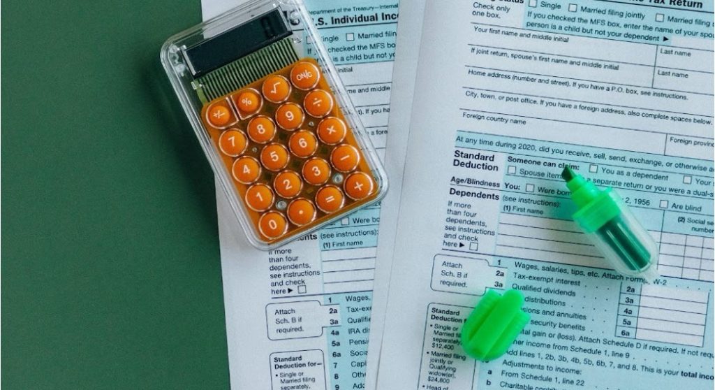 Calculator with legal documents showing litigation cost breakdown.