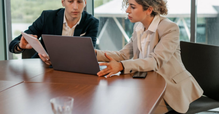 Professional business meeting with two executives reviewing documents.