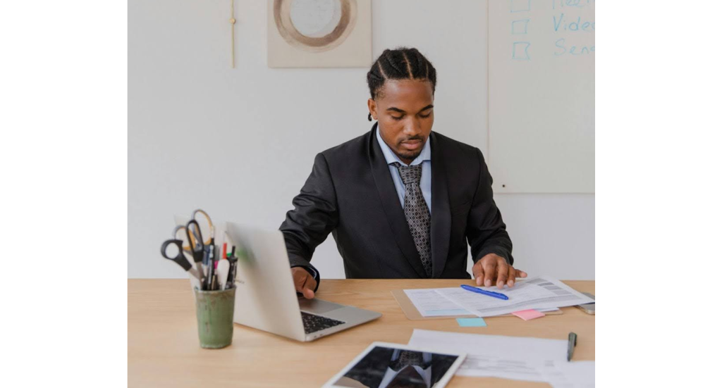 Business owner reviewing collection agency pricing structures on a laptop.