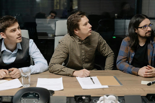 Business professionals reviewing documents and discussing collection strategies at a conference table.