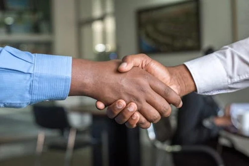Close-up of two professionals shaking hands in an office setting