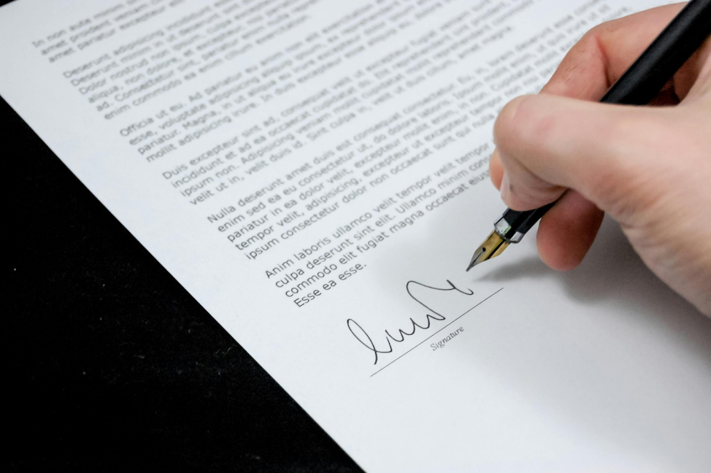 Hand signing a document with a fountain pen.