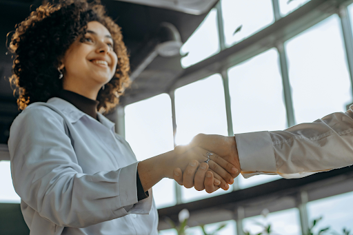 Two professionals shaking hands in a modern office setting