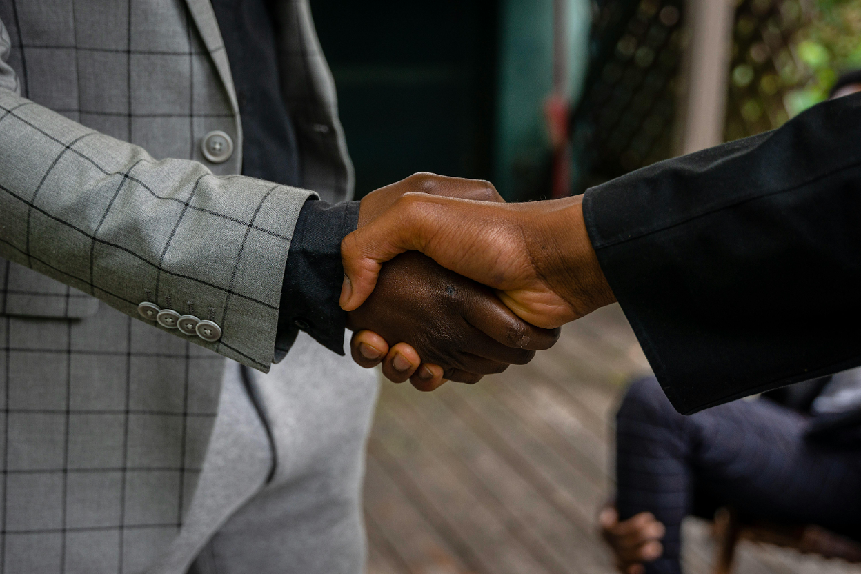 Close-up of two business professionals in suits shaking hands, symbolizing agreement or partnership.