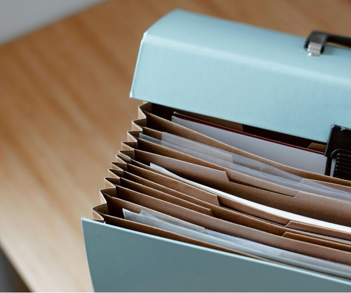 Organized file folders containing business contracts and financial records