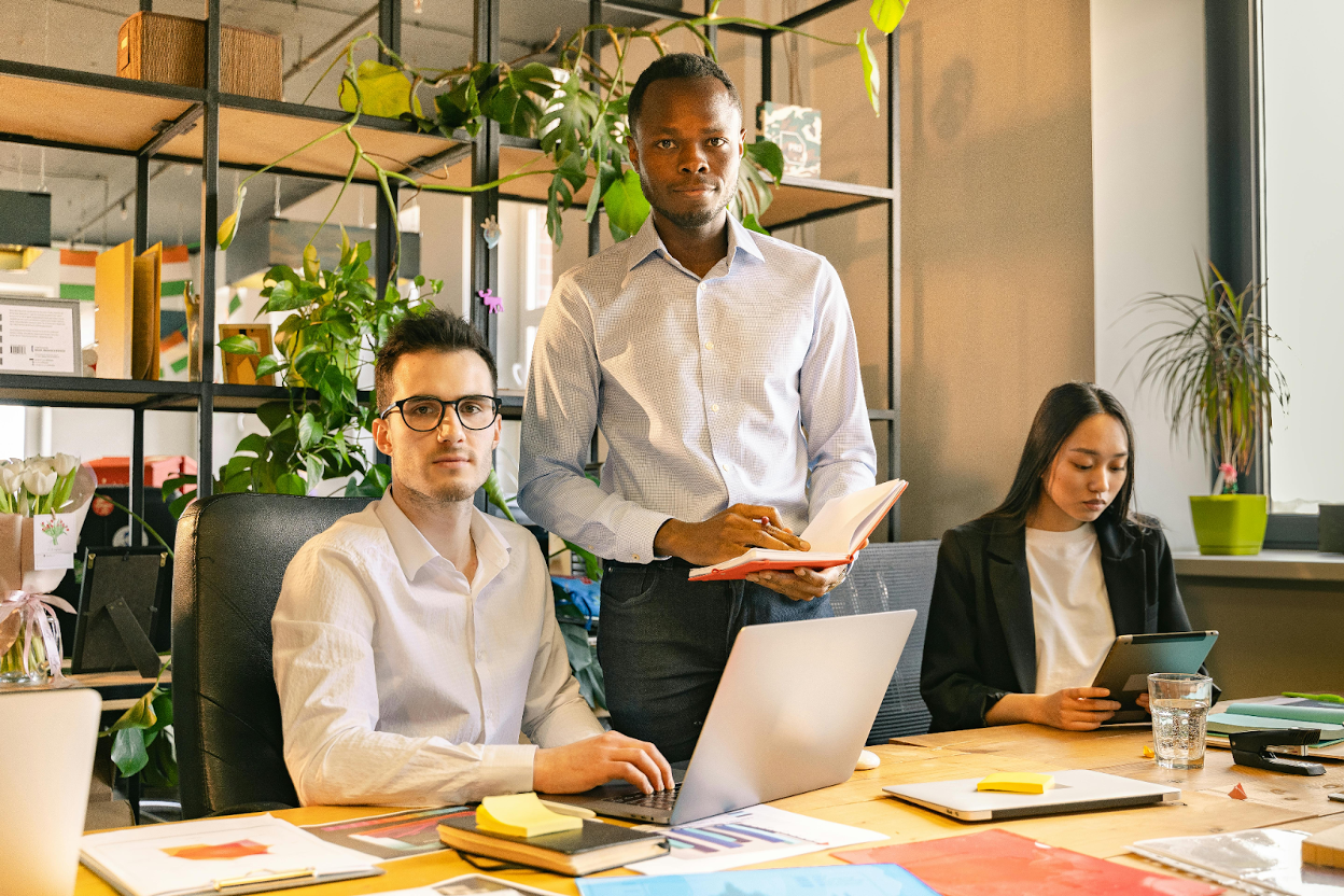 Three colleagues working in a modern office with plants