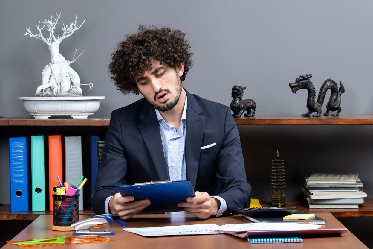 A business professional working with a calculator and financial documents at a desk