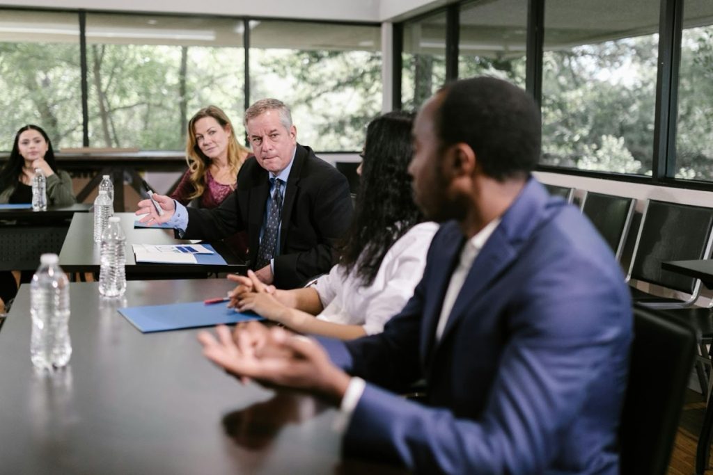 Business professionals reviewing debt collection cost breakdowns at a conference table in a modern Tampa office