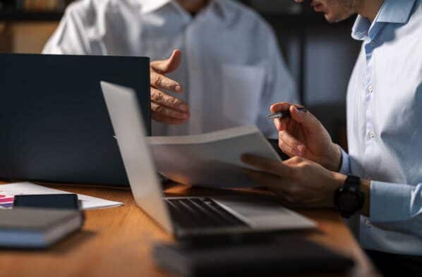 Agents from a collection agency for HOA management companies reviewing account documentation